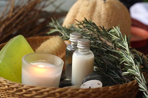 A basket filled with spa products and rosemary.