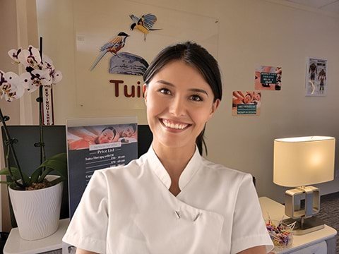 A tuina therapist standing in front of the 2 birds tuna spa front desk.